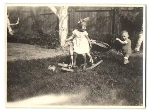 Fotografie Mädchen mit Schaukelpferd & Knabe schiebt Puppenwagen