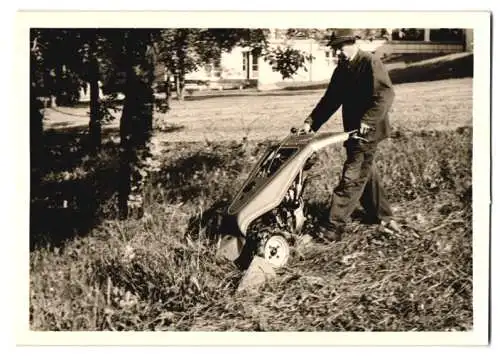 Fotografie Landschaftsgärtner mit Rasenmäher beim Trimmen einer Wiese