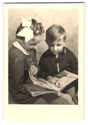 Fotografie Charlotte Räder, Berlin-Tempelhof, Mädchen und Knabe schauen sich Kinderbuch an