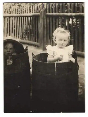 Fotografie Kinder spielen verstecken in alten Holzfässern