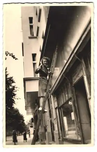 Fotografie Ladenbesitzerin streicht die Grundfläche für das Ladenschild neu