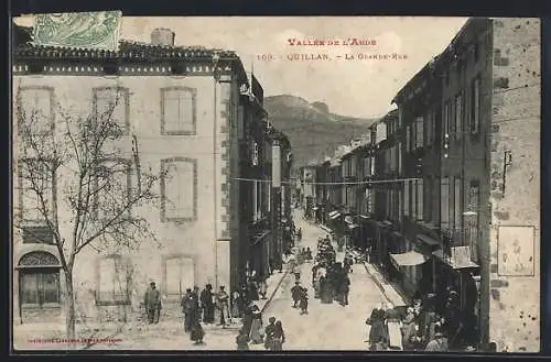 AK Quillan, La Grande-Rue avec des passants et des bâtiments en arrière-plan