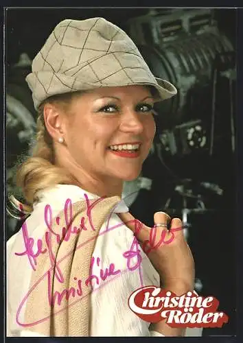 AK Musikerin Christine Röder breit lächelnd mit eniem Hut und der Strickjacke über der Schulter, mit Autograph