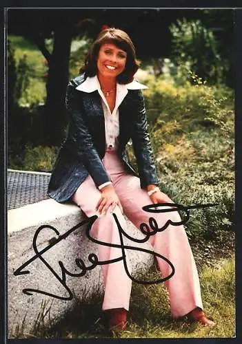 AK Musikerin Ireen Sheer breit lächelnd in blauer Jacke und roas-farbener Hose, Autograph