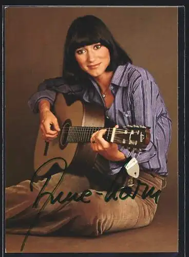 AK Musikerin Anne-Karin in sitzender Position beim Gitarre spielen, mit Autograph