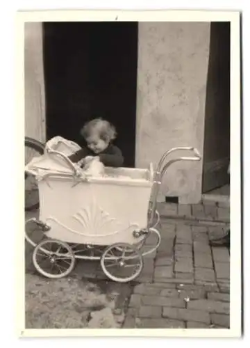 Fotografie kleines Mädchen durchsucht Kinderwagen, Westerstede 1943