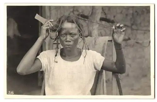 Fotografie Afrikanerin beim Kämmen und frisieren von Dreadlock's