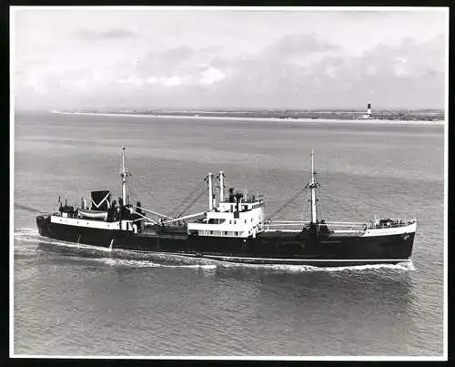 Fotografie Frachtschiff / Frachter Caledonian Coast, Leuchtturm im Hintergrund