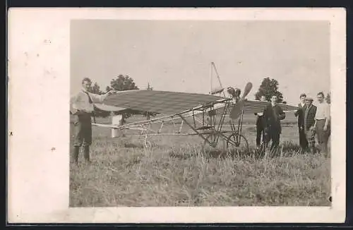 AK Menschengruppe vor einem Eindecker-Flugzeug auf einem Feld