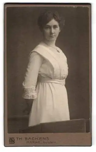 Fotografie Th. Backens, Marne i. Holstein, Porträt einer Dame in weissem Kleid