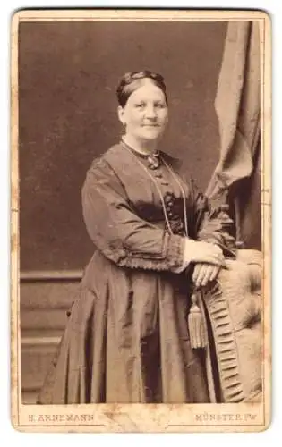 Fotografie H. Arnemann, Münster i. W., Frauenstrasse 19, Lächelnde Dame mit Zopffrisur