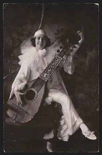 AK Harlekin mit Instrument auf einer Armlehne