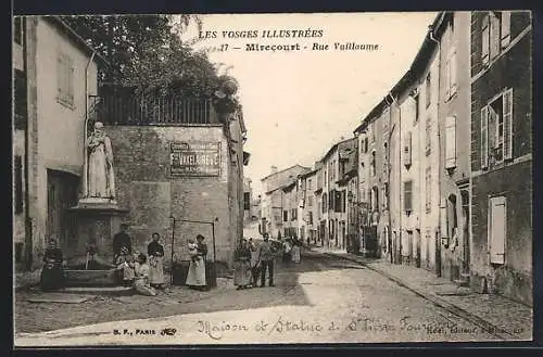 AK Mirecourt, Rue Vuillaume avec la statue de Saint-Pierre Fourier et passants