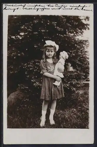 Foto-AK Mädchen mit Schleife im Haar hält ihre Puppe im Arm