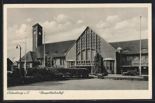 AK Oldenburg / O., Bahnhof Frontalansicht mit Parkanlge und Auto