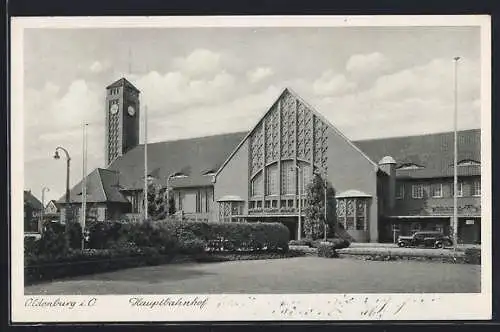 AK Oldenburg / O., Bahnhof Frontalansicht mit Parkanlge und Auto