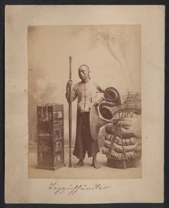 Fotografie Gustav Richard Lambert & Co., Singapur, Asiatischer Teppichhändler mit seinen Waren 0