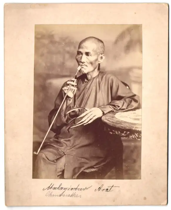 Fotografie Gustav Richard Lambert & Co., Singapur, Asiatischer Teppichhändler mit seinen Waren 2