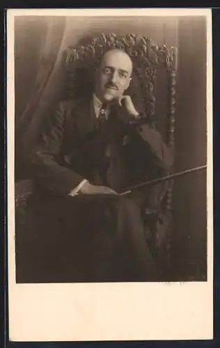 AK Mann sitzt in einem Stuhl mit seiner Geige