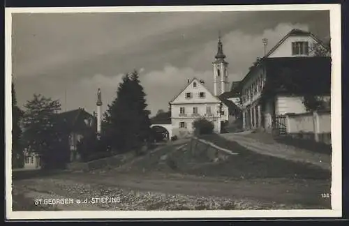 AK St. Georgen a. d. Stiefing, Gasthaus Th. Luttenberger, dahinter die Kirche