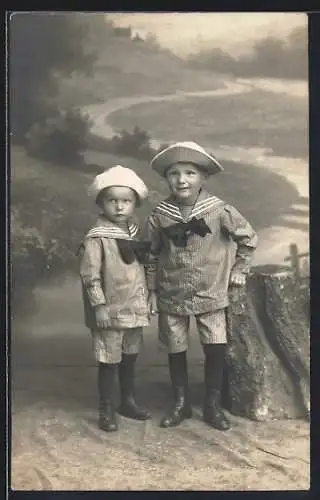 Foto-AK Zwei kleine Jungen in Matrosenanzügen vor einer Studiokulisse mit Baumstumpf