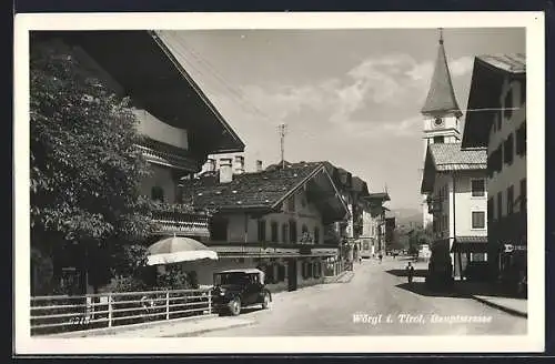 AK Wörgl, Hauptstrasse mit Gemischtwarenhandlung und Kirche, Auto