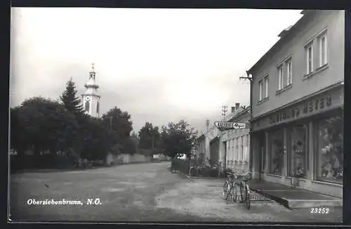 AK Obersiebenbrunn, Kaufhaus Meyer mit Blick zur Kirche, Fahrräder