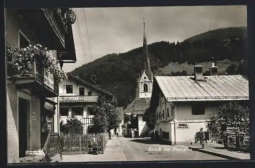 AK Bruck im Pinzgau, Strassenpartie mit Blick zur Kirche