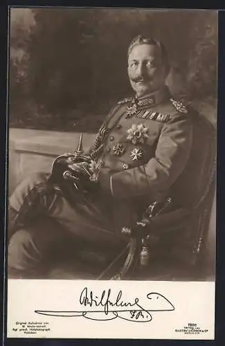 AK Kaiser Wilhelm II. sitzt auf einem Stuhl mit Orden und Pickelhaube auf dem Schoss