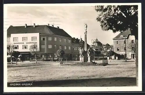 AK Sadska, Strassenpartie mit Denkmal und Sparkasse