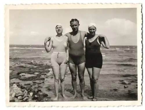 Fotografie Herr nebst zwei Damen in Badeanzügen am Strand, Bademode