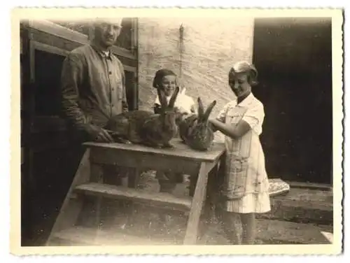 Fotografie Bauer zeigt kleinen Mädchen seine Hasen, 1937