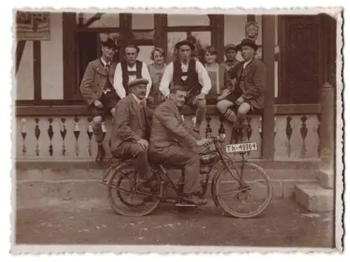 Fotografie zwei Herren auf einem Stock Motorrad / Mofa mit Kennzeichen: Th-49964, dahinter Männer in Tracht