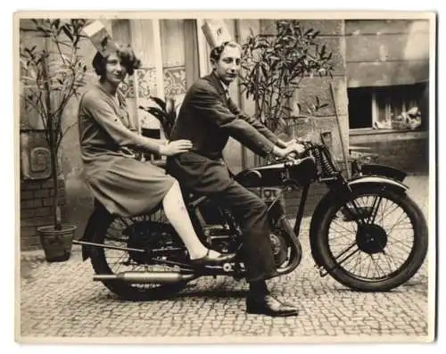 Fotografie junges Paar auf einem Vincent H. R. D. Motorrad mit Papiertüten auf dem Kopf