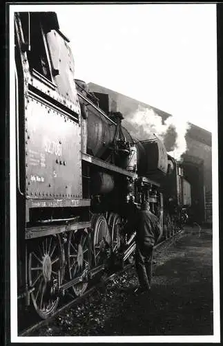 Fotografie österreichische Eisenbahn ÖBB, Eisenbahner schmiert Antriebsteile an Lokomotive - Dampflok Nr. 52.7061 ab