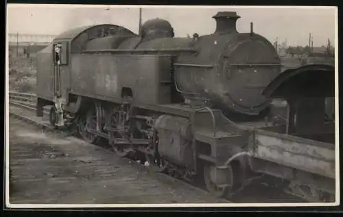 Fotografie britische Eisenbahn, Dampflok, Lokomotive schiebt Güterzug an