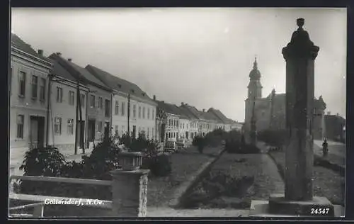 AK Göllersdorf, Strassenpartie mit Heiligenstatuen und Kirche