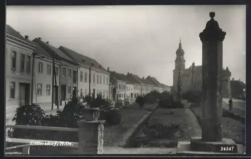 AK Göllersdorf, Strassenpartie mit Heiligenstatuen und Kirche