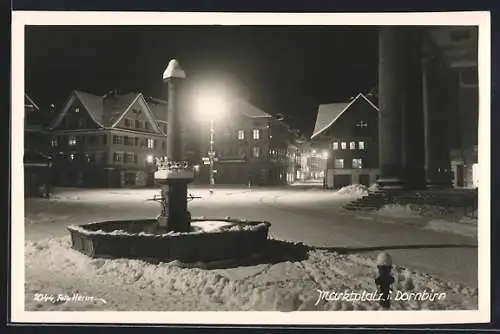 AK Dornbirn, Marktplatz mit Brunnen im Schnee bei Nacht