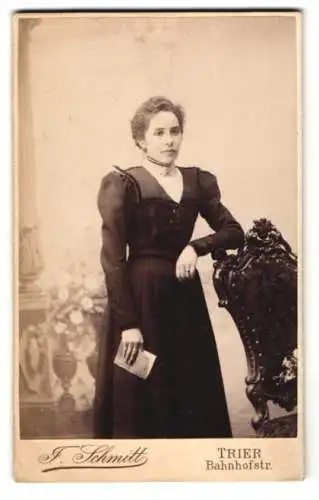 Fotografie J. Schmitt, Trier, Bahnhofstr., Frau im eleganten Kleid mit Buch in der Hand