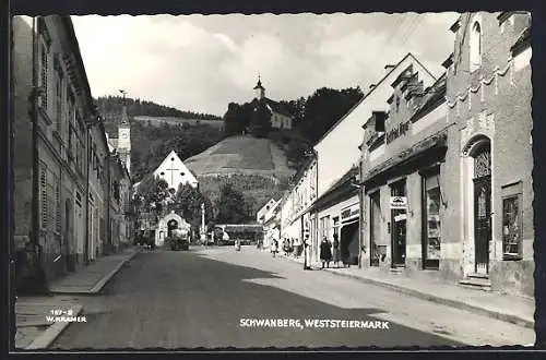 AK Schwanberg, Strassenansicht mit Geschäften und Blick auf die Kirche