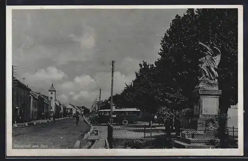 AK Neusiedl, Strassenpartie mit Denkmal und Bus