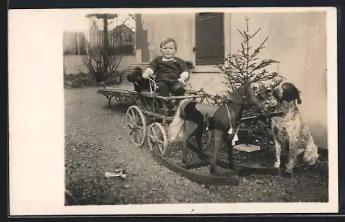 Foto-AK Kind sitzt in einem Wagen mit vorgespanntem Schaukelpferd