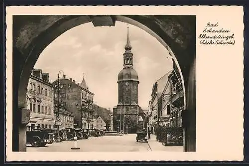 AK Bad Schandau, Marktstrasse mit Geschäften und Kirche durch Tor