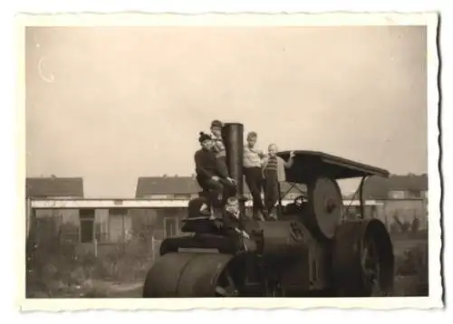 Fotografie Baumaschine Dampfwalze, Knaben klettern auf Strassenwalze herum