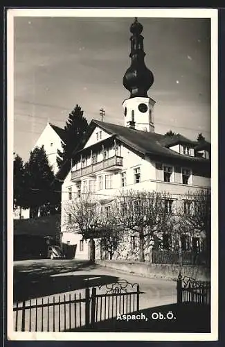 AK Aspach /Ob. Ö., Strassenpartie mit Kirchturm