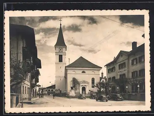 AK Wörgl, Unterinntal, Strassenpartie mit Kirche, Gasthof mit davor parkenden Autos