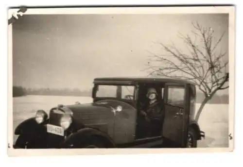 Fotografie Auto Essex, junge Frau im Wintermantel bei geöffneter Selbstmördertür