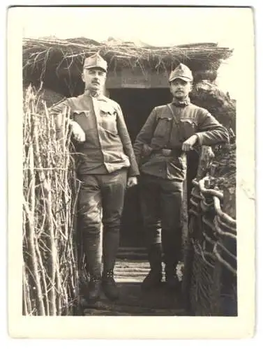 Fotografie zwei K.u.K. Soldaten in Uniform posieren vor einem Unterstand, Schützengraben