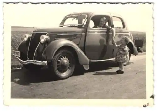 Fotografie Mutter im Ford Eifel hält die Hand ihrer Tochter